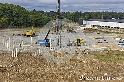 Industrial view of construction site with machinery and pile driving machine for driving piles into ground. Editorial Stock Photo