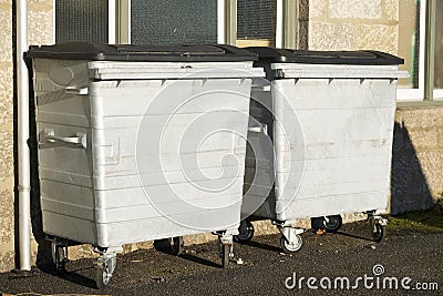 Industrial waste bins at council school with black rubber lid Stock Photo