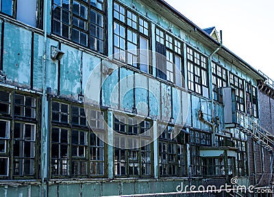 Industrial weathered urban building with rusting window grill and discoloured painted wall surface Stock Photo