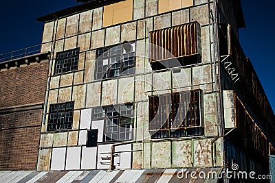 Industrial weathered urban building with rusting window grill and discoloured painted wall surface Stock Photo