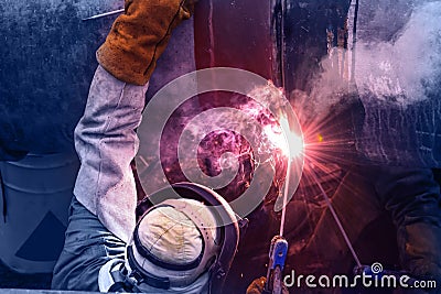 Industrial welding, Worker with protective mask welding bore pile metal casing at a construction site Stock Photo