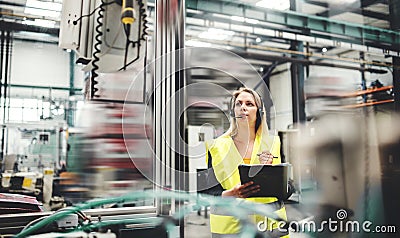 Industrial woman engineer with headset in a factory, working. Copy space. Stock Photo