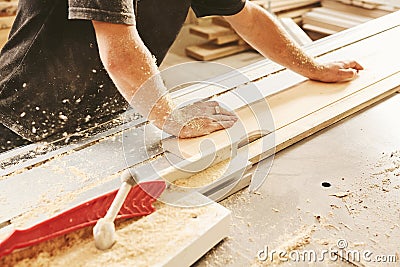 Industrial worker cuts wood on a woodworking machine, close-up. Stock Photo