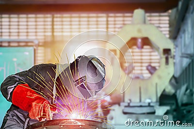 Industrial Worker in factory in welding MIG Weld with spark light. Stock Photo