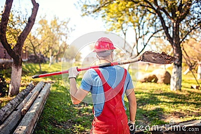 Industrial worker with helmet and work wear using a spade to dig a tunnel. agriculture concept with worker Stock Photo