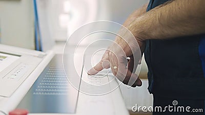 Industrial Worker. Man using control panel of the Printing machine. Stock Photo