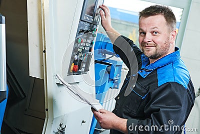 Industrial worker operating cnc turning machine in metal machining industry Stock Photo