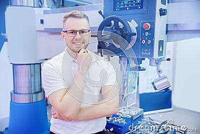 Industrial worker operator use automated drill CNC turning machine at automatic modern factory floor. Concept engineer Stock Photo
