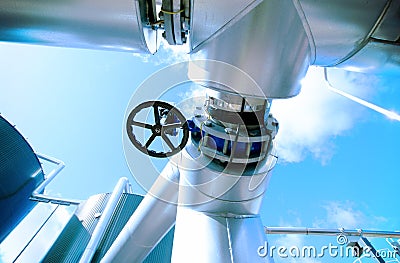 Industrial zone, Steel pipelines valves against blue sky Stock Photo