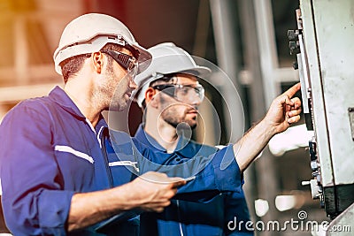 Industry engineer team worker teaching help friend operate control heavy machine in factory Stock Photo