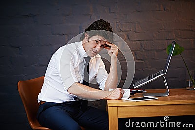 In this industry were always working to a deadline. Portrait of a businessman working late at the office. Stock Photo