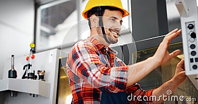 Industry Worker entering data in CNC machine at factory Stock Photo