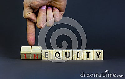 Inequity or equity symbol. Businessman turns wooden cubes and changes the word inequity to equity. Business and inequity or equity Stock Photo