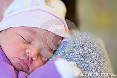 Mom holds her one month old baby girl on the shoulder while she is sleeping. Stock Photo