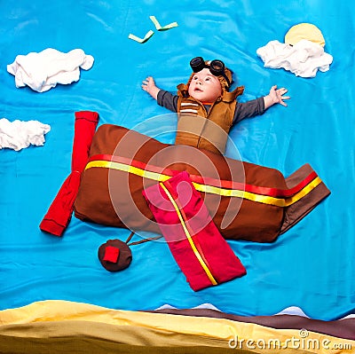 Infant baby boy wearing an aviator hat and outfit flying Stock Photo