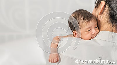 Infant baby holding on shoulder with love of happy smilling mother Stock Photo
