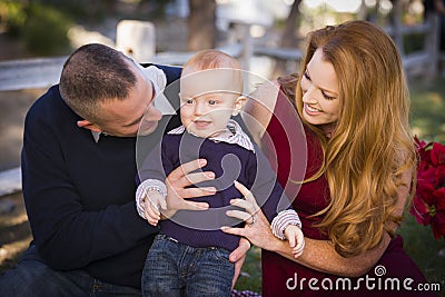 Infant Boy and Young Military Parents Play in the Park Stock Photo