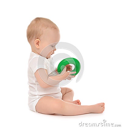 Infant child baby boy toddler playing holding green circle in ha Stock Photo