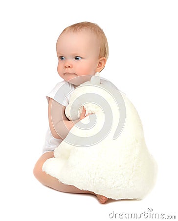 Infant child baby girl hugging soft teddy bear sleeping on Stock Photo