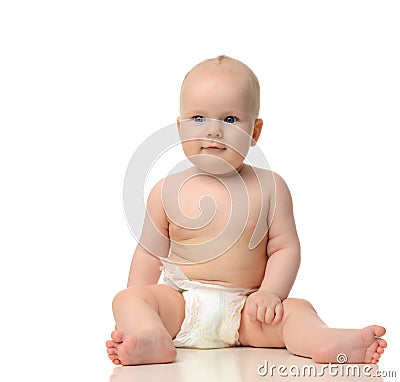 Infant child baby girl toddler sitting in diaper looking a Stock Photo