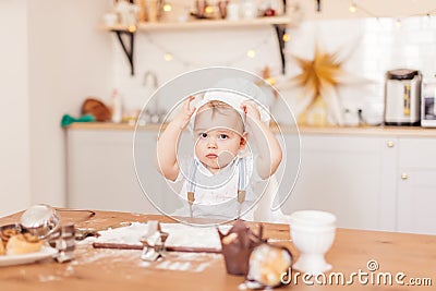 Infant cook baby portrait wearing apron and chef hat testing Stock Photo