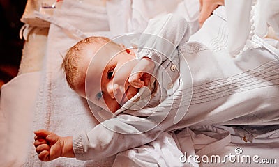 An infant is lying on a dressing table in the Church. the ordinance of baptism. Stock Photo