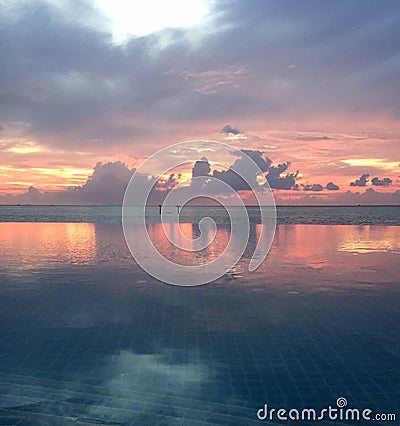 Infinity pool on the beach at sunset Stock Photo