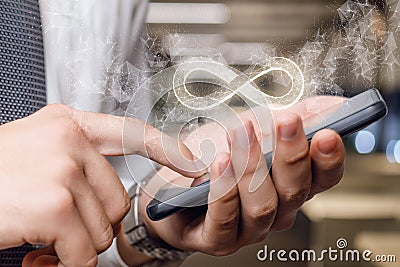 An infinity sign appears from the phone Stock Photo