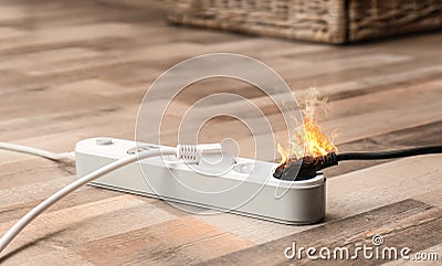 Inflamed plug in power board - electrical short circuit Stock Photo