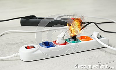 Inflamed plug in power board - electrical short circuit Stock Photo