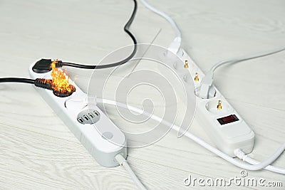 Inflamed plug in power board - electrical short circuit Stock Photo