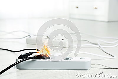 Inflamed plug in power board - electrical short circuit Stock Photo