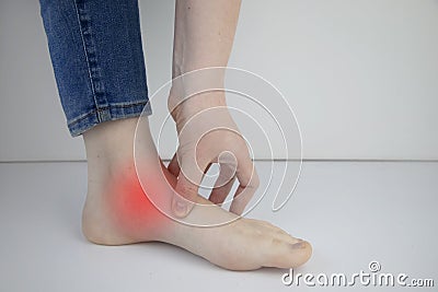 Woman suffering from heel pain. Inflammation or sprain of the tendon in the foot, heel spur, bursitis. The concept of diseases and Stock Photo