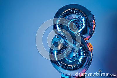 Inflatable ball eight in neon light holds a boy Stock Photo