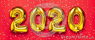 2020 inflatable golden numbers with confetti in the shape of stars on red background. New year winter decoration, holiday symbol. Stock Photo