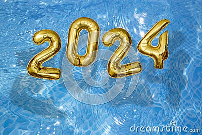 2024 Inflatable golden numbers on water ripples surface, happy new year with a swimming pool Stock Photo