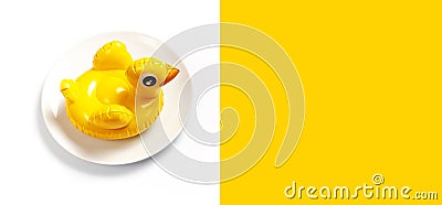 Inflatable mini yellow chicken or duckling on white plate on white background. Creative food concept, tobacco chicken. Flat lay Stock Photo