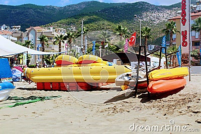 Inflatable rafts, boats and other equipment on the sand in front of the water entertainment center on the beach in Alanya Editorial Stock Photo