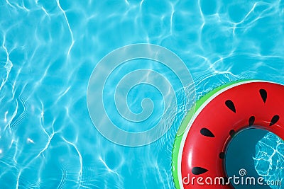 Inflatable ring floating in swimming pool on sunny day Stock Photo