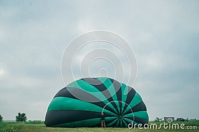 Inflating, unpack and flying up hot air balloon watermelon. Burner directing flame into envelope. Take off aircraft fly Stock Photo