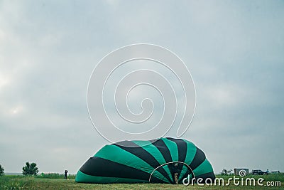 Inflating, unpack and flying up hot air balloon watermelon. Burner directing flame into envelope. Take off aircraft fly Stock Photo