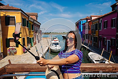 Influence media Burano Italy. Paint building house in Europe Venezia city. Travel photographer blogger girl with Editorial Stock Photo