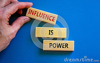 Influence is power symbol. Wooden blocks with words `Influence is power`. Beautiful blue background, businessman hand. Business, Stock Photo