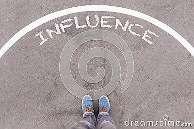 Influence text on asphalt ground, feet and shoes on floor Stock Photo