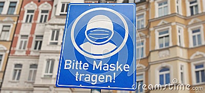 Info sign with German text `Bitte tragen Sie eine Maske!` `Please wear a mask!` Stock Photo