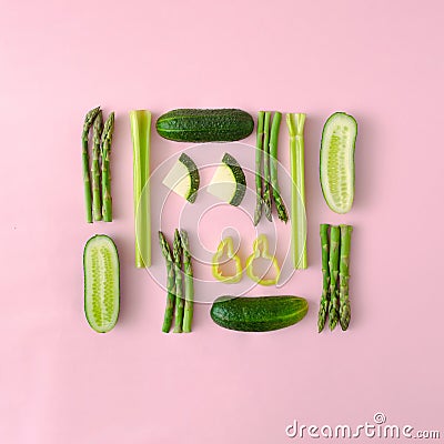 Infographic made of organic asparagus, cucumbers, green paprika and zucchini on a pastel pink background. Stock Photo