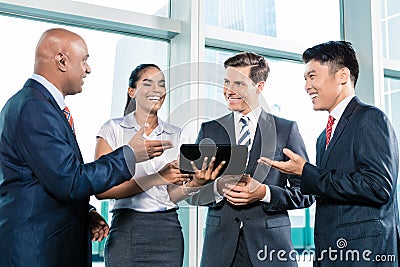 Informal business people with table computer discussing Stock Photo