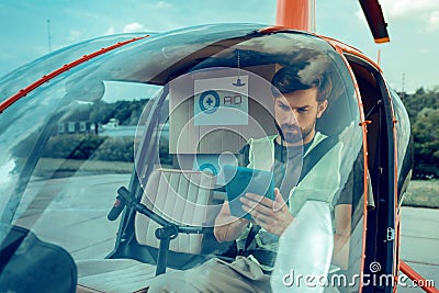 Attentive serious guy with black bearded sitting in the helicopter Stock Photo