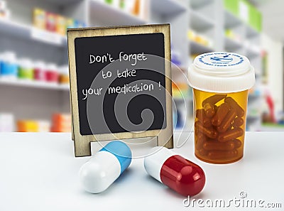 Informational Sign in a pharmacy, do not forget to take your medication, on a whiteboard next to bottles of medicines Stock Photo