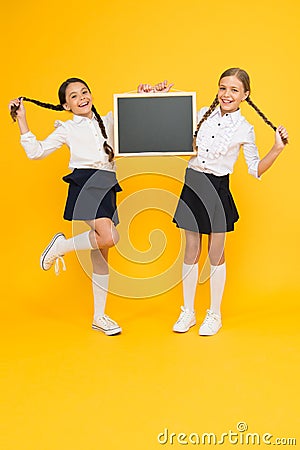 Informing changes. School girls cute pupils hold blackboard copy space. School announcement concept. Classmates Stock Photo